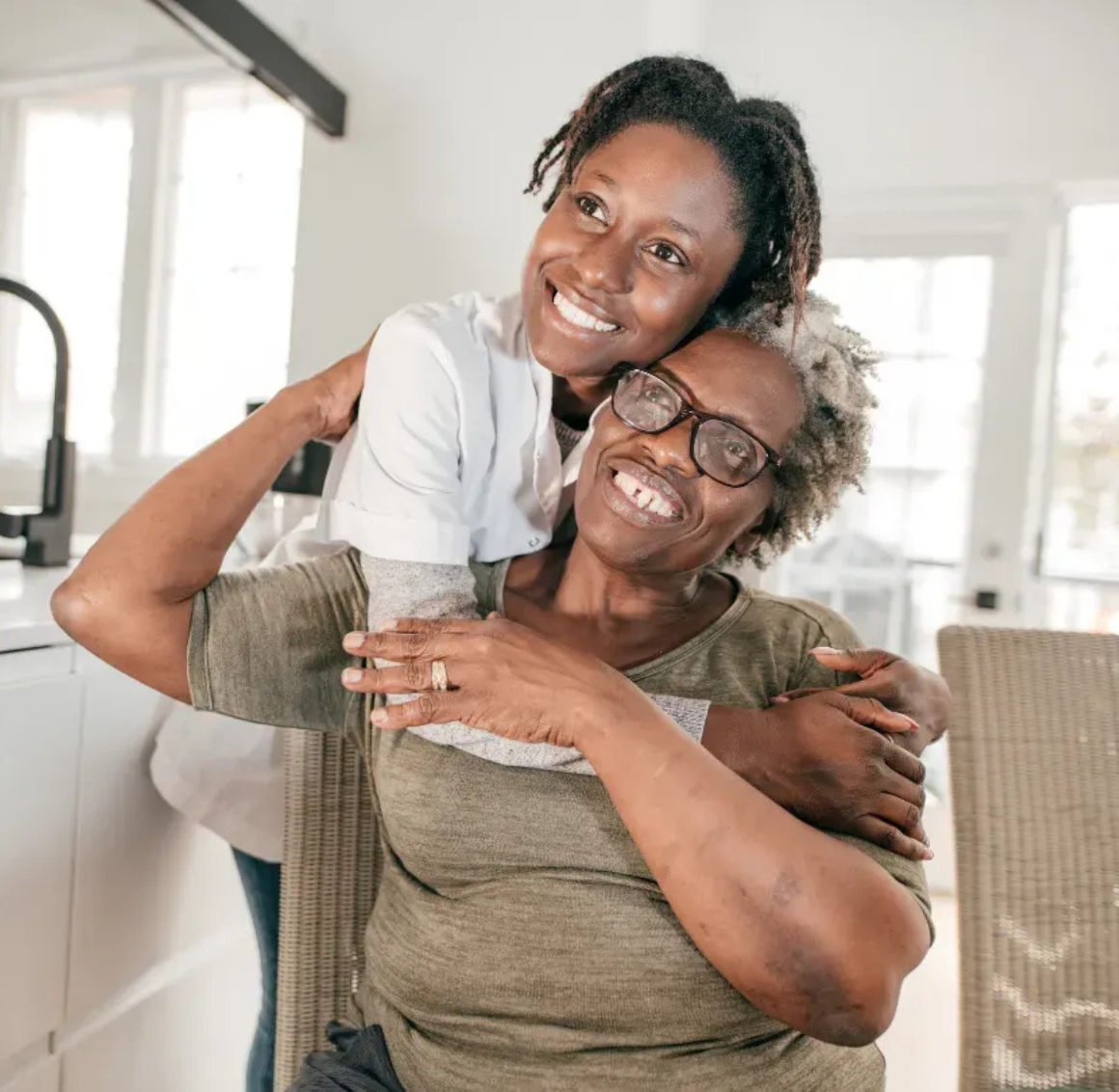 Caregiver embracing an older woman at home Caregiver embracing an older woman at home